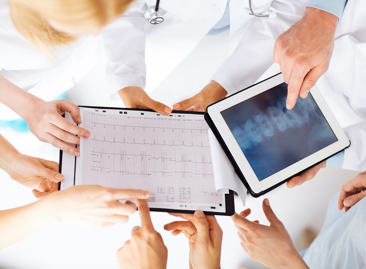 group of doctors looking at x-ray on tablet pc